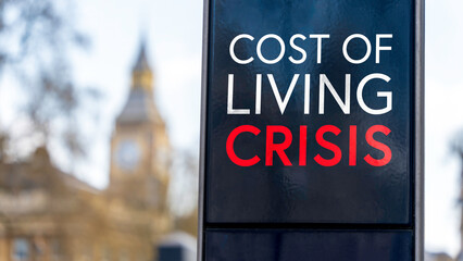Cost of Living Crisis written on a sign with Elizabeth Tower and Big Ben in the background	