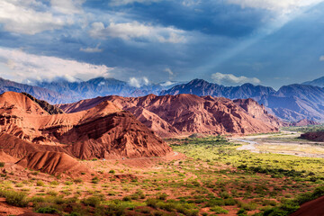 Arid and wild landscape, with mountains and river, with lights, shadows and vehicles circulating.