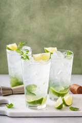 Cold refreshing mojito with lime and mint in tall glasses