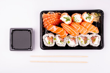 japanese food sushi delivery isolated on background top view on white background with chopsticks and soy sauce