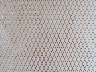 silver steel mesh in front of grey concrete wall, diagonal metallic grating for hanging products display in stall at flea market - obrazy, fototapety, plakaty