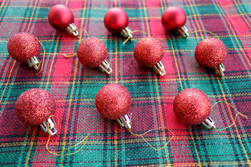 Red Christmas balls on green red striped fabric