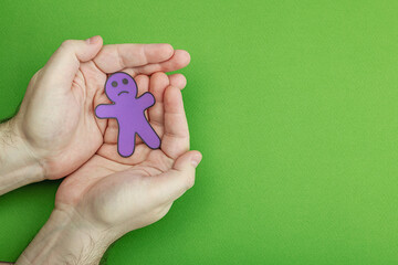 World mental health day. Male hands holding paper men figures with different emotions