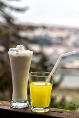 A chocolate-flavored milkshake with a side of lemonade stands next to it
