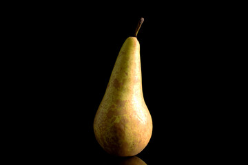 One ripe pear, macro, isolated on black background.