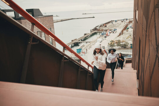 Three female friend running up stairs