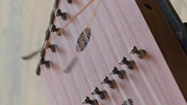 Vertical video. Close-up of street musician playing on santoor or cimbalom, slow motion. Music and arts concept