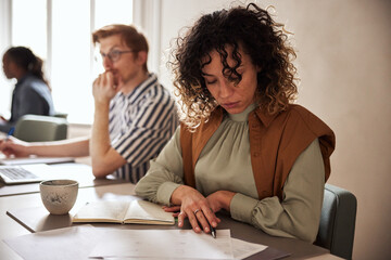 Young businesswoman reading notes at work