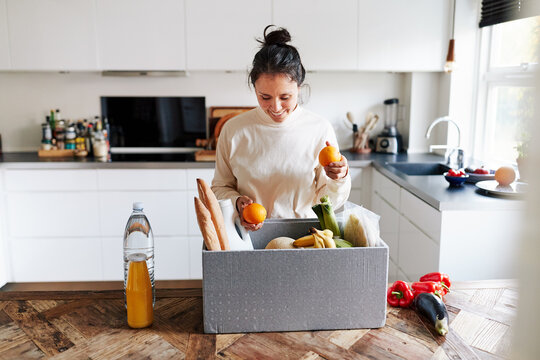 Smiling woman unpacking her grocery delivery