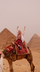 European woman on the camel a front of Giza pyramid in Cairo Egypt travel photography 