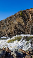 Spring landscape with waterfall on the northern river with stone banks