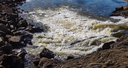 Spring landscape with waterfall on the northern river with stone banks