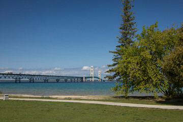 The Mackinac Bridge on a summer day. A suspension bridge spanning the Straits of Mackinac to connect the Upper and Lower Peninsulas of Michigan. Clouds in a blue sky