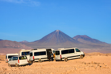 Carros de turismo no Vale da Lua (Valle de La Luna) circulando no deserto do Atacama, próximos ao...