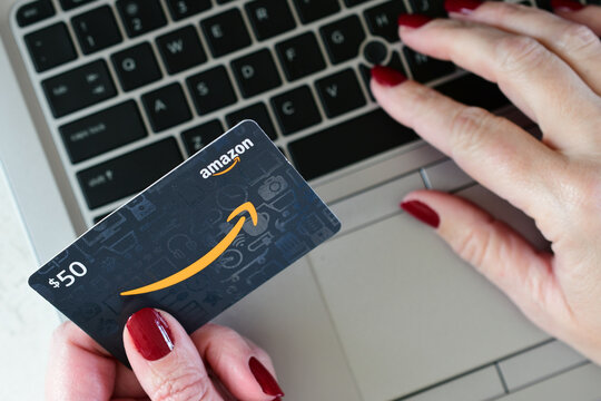 Female shopping online laptop computer with an Amazon gift card