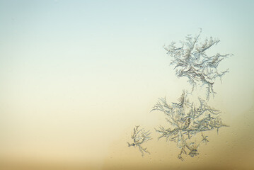 ice crystal close up on window pane against winter sky empty space background