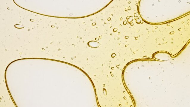 Transparent cosmetic gel fluid with molecule bubbles oil distribution on a white background. Macro Shot of Natural Organic Cosmetics, Medicine. Production Close-up. Slow Motion. High quality 4k