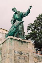 Fototapeta premium a statue in a courtyard with steps going up it, which is surrounded by tall