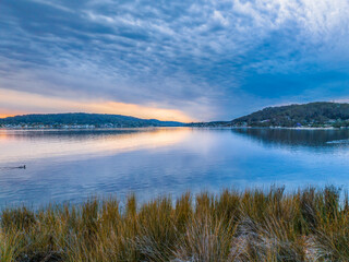 Heavy cloud covered sunrise over the bay with colour and reflections