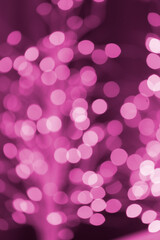 Christmas pink glowing background. Pink festive abstract shiny defocused background with flashing garlands.