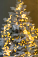 Christmas room with golden bokeh. A blurry image of an atmospheric Christmas Eve. Unfocused Christmas tree with backlit close-up.