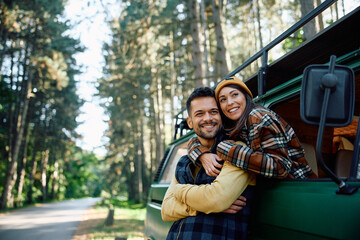 Happy couple in love enjoys in their camping journey in woods.