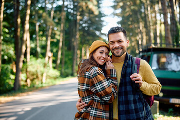 Fototapeta premium Portrait of happy couple of campers in woods looking at camera.