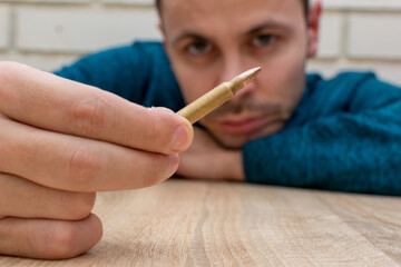 A man looks at a dangerous live cartridge