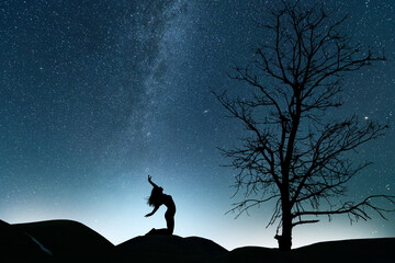 Woman silhouette  in the night, on the bright Milky Way Galaxy background.