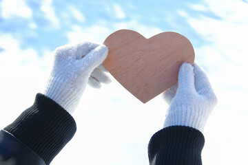 A Heart in the hands of a girl against the sky Valentine's day in a park in nature