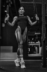 Fototapeta na wymiar Black and white image of a sexy fitness woman. A beautiful sportswoman is training in the gym.