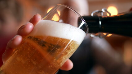 Filling Glass with Beer at Restaurant, traditional golden pour, close-up face holding refreshing drink