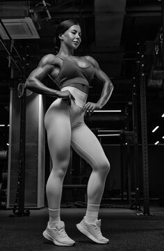 Black and white image of a sexy fitness woman. A beautiful sportswoman is training in the gym.