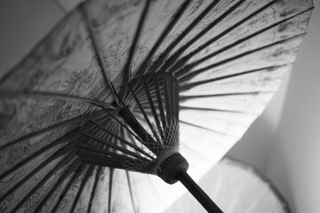 An aged and antique parasol umbrella in black and white.
