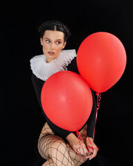 Portrait of woman hold helium balloon, female holding ballon in front her face against black background, holiday, celebration