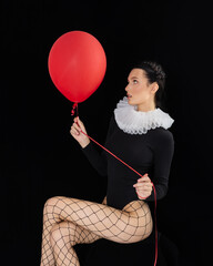 Portrait of woman hold helium balloon, female holding ballon in front her face against black background, holiday, celebration