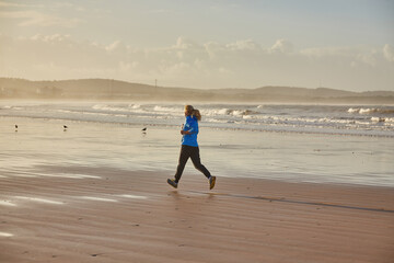 A young woman embraces the tranquility of a seaside run along Essaouira's ocean