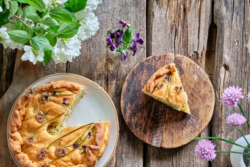 Potato pie decorated with edible flowers. Chives and viola flowers. Spring