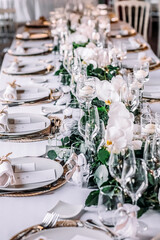 Wedding hall with white chairs, white tablecloths and wine glasses