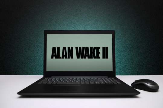 Alan Wake 2 game on laptop screen with mouse on black textured wall with green light. Astana, Kazakhstan - November 13, 2023.