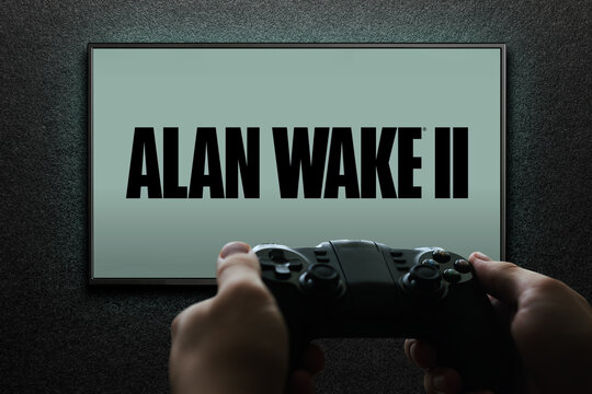 Alan Wake 2 game on TV screen with gamepad in hand on black textured wall with light. Astana, Kazakhstan - November 13, 2023.