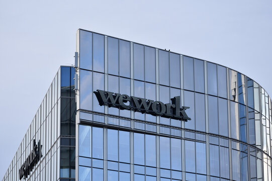 WeWork signage, logo on the building facade. Coworking office space. WARSAW, POLAND - AUGUST 28, 2021