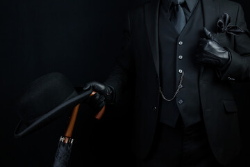 Portrait of British Businessman in Dark Suit Holding Umbrella and Bowler Hat. Mafia Hitman or Gangster. - obrazy, fototapety, plakaty