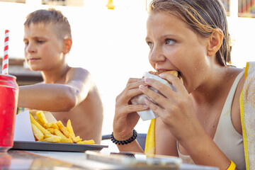 summer holiday concept. Focus on girl, unhealthy food, children eat unhealthy food, fast food