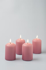 Christmas traditions, advent. Four light pink candles on a light background.