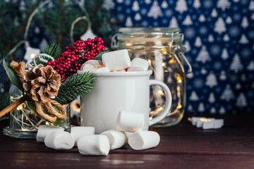 Christmas drink hot chocolate with marshmallows at festive illuminated decoration. Selective focus