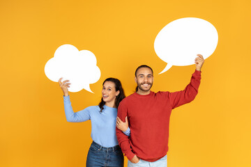 Portrait young couple holding empty speech bubbles with free space