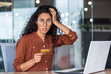 Portrait of unhappy and cheated business woman at workplace, female employee with bank credit card and laptop looking excited and nervous at camera, received fund transfer rejection, password error