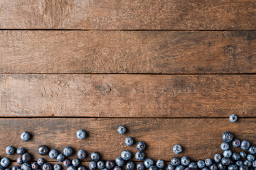 Tasty bilberries on wooden background with copyspace. Top view - obrazy, fototapety, plakaty