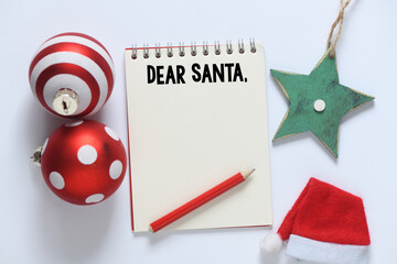 Lettering wish card written to Dear Santa text by kid on white desk with Christmas.